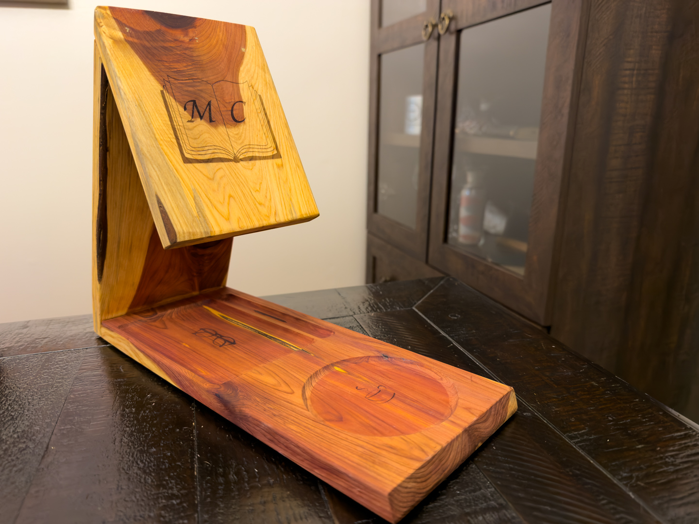 Handcrafted wooden display stand with natural grain A nameplate on a wooden desk plaque with a decorative metal emblem.