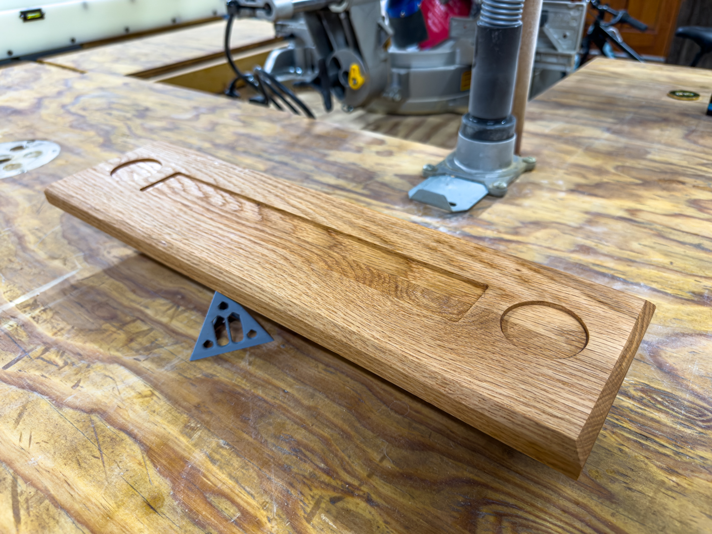 Custom oak nameplate on a woodworking bench A carved oak desk nameplate rests on a worn woodworking bench in a workshop.
