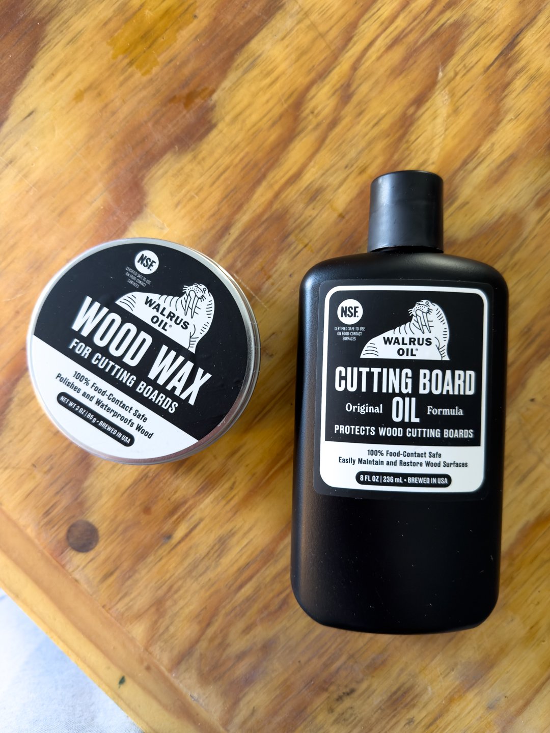 Wood care products, a bottle of oil and a jar of wax, arranged on a bench