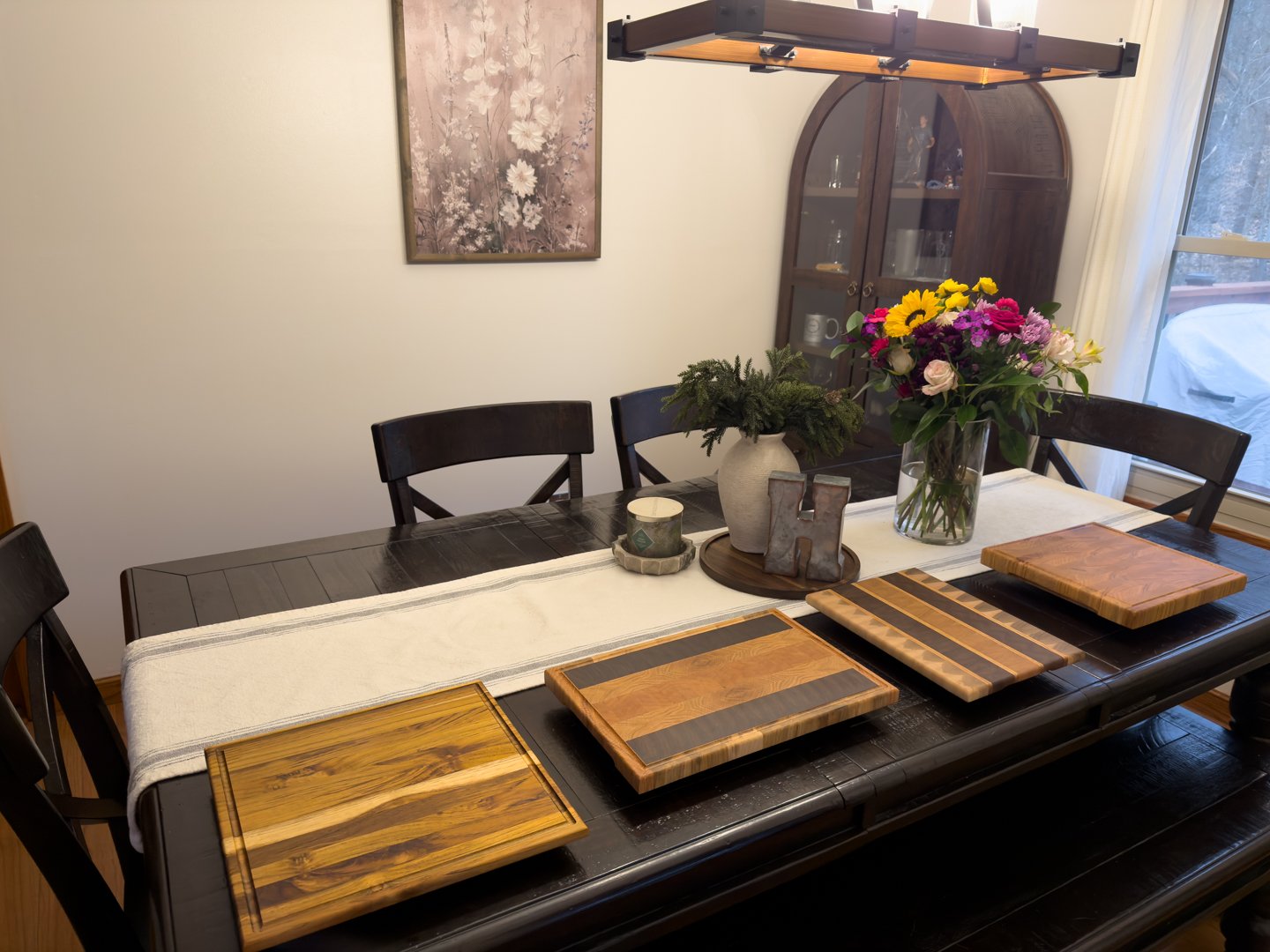 A dining table set with several handcrafted wooden cutting boards