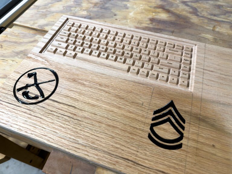 The oak panel with carved keys and two engraved emblems on the workbench.