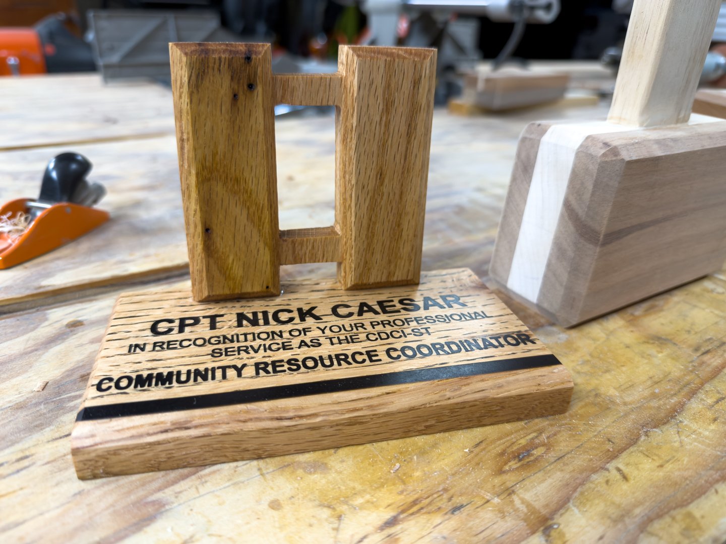 Oak captain's bars award with beveled edges, standing in an engraved base with a black epoxy inlay