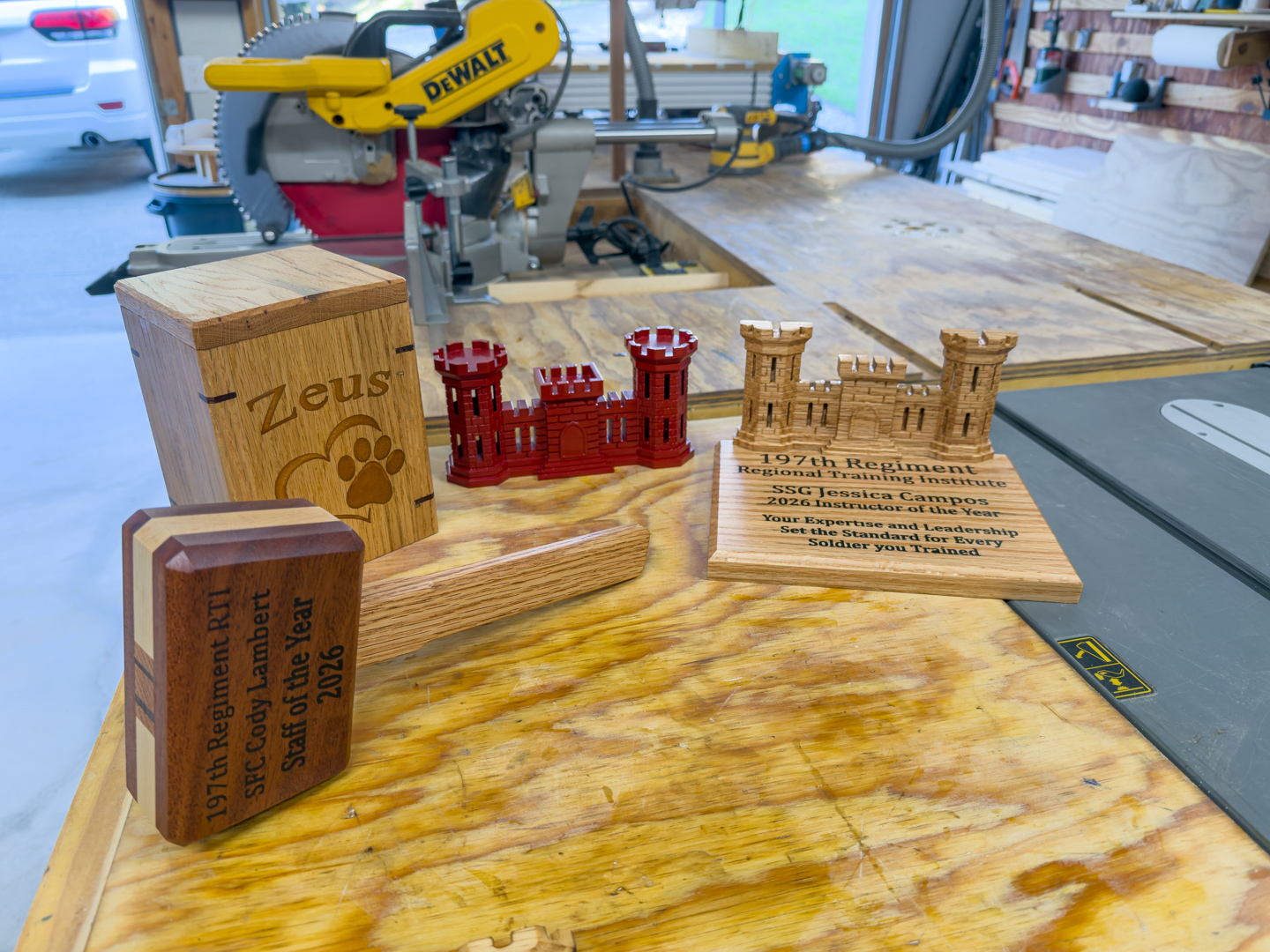 Several wooden award plaques, some engraved, set on a shop workbench