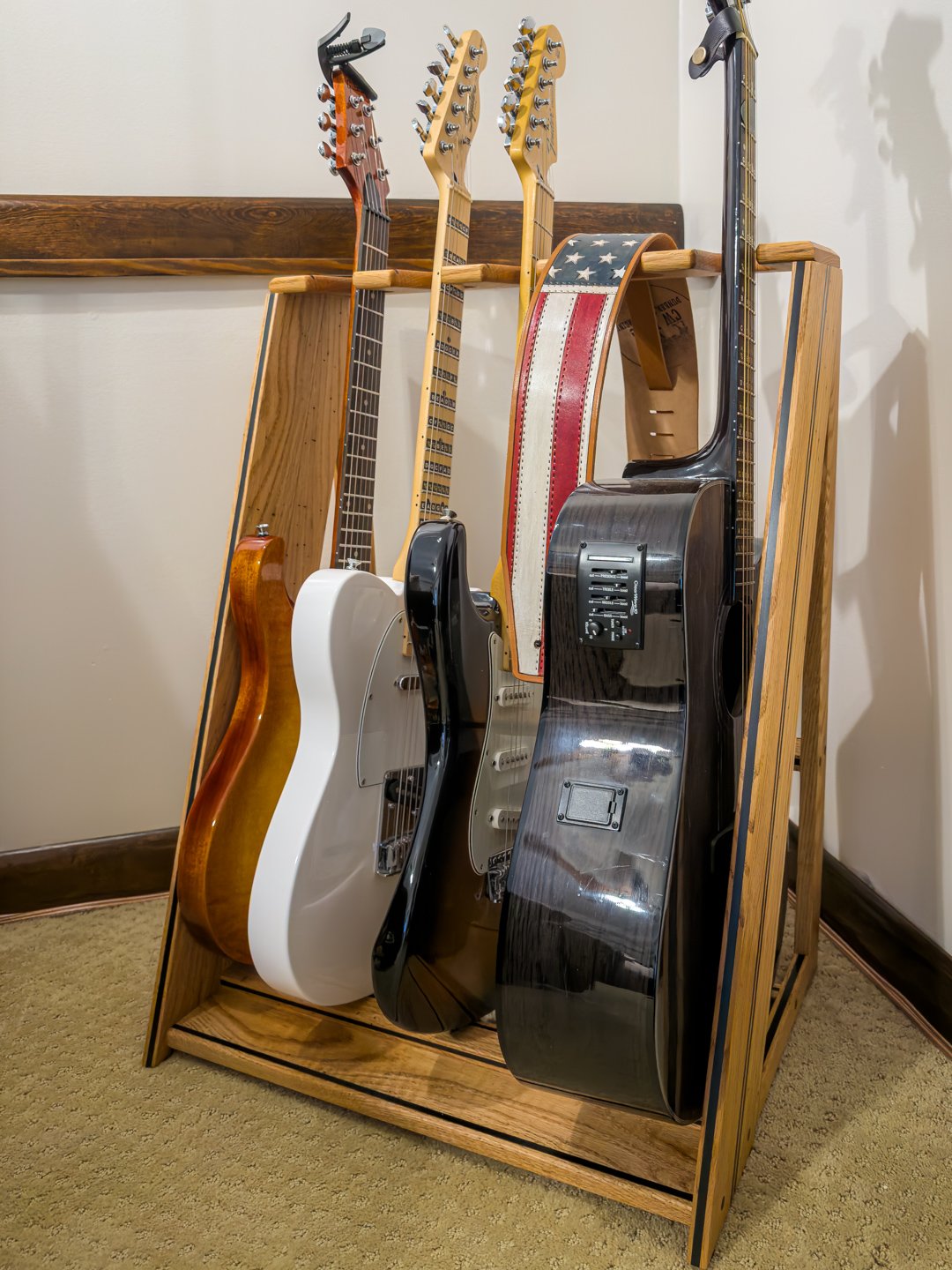 Front view of a wooden multi-guitar rack holding several electric guitars upright in a row