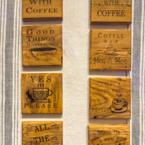 Engraved coffee wooden coaster set with eight coffee sayings displayed on a table
