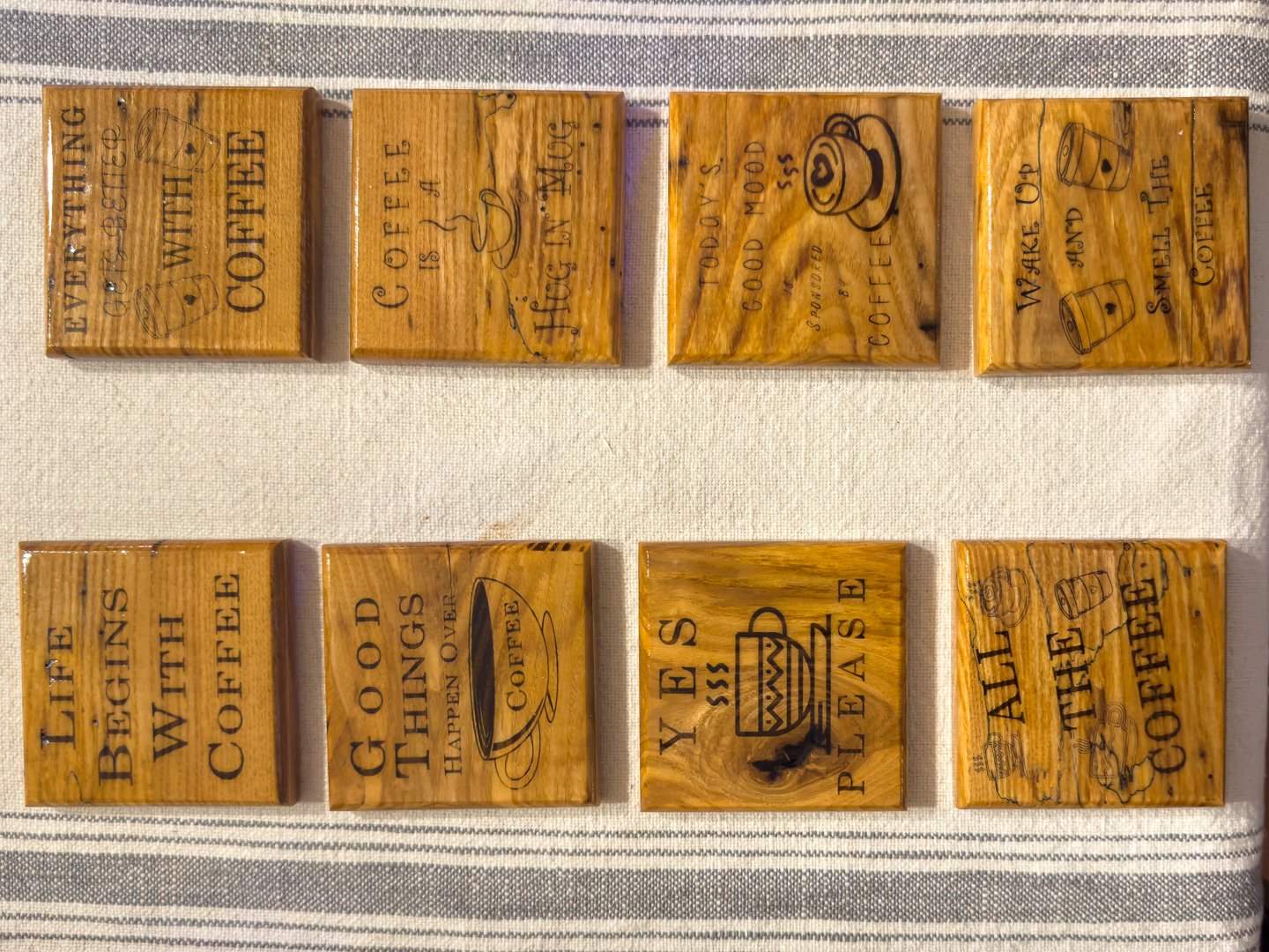 Engraved coffee wooden coaster set with eight coffee sayings displayed on a table