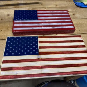 Handcrafted wooden American flag wall art panel leaning on a surface, red and white stripes with a blue star field