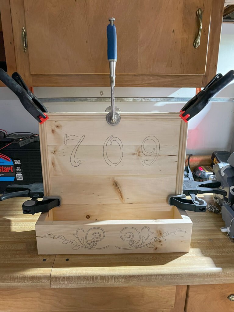 The planter box held together with clamps on the workbench.