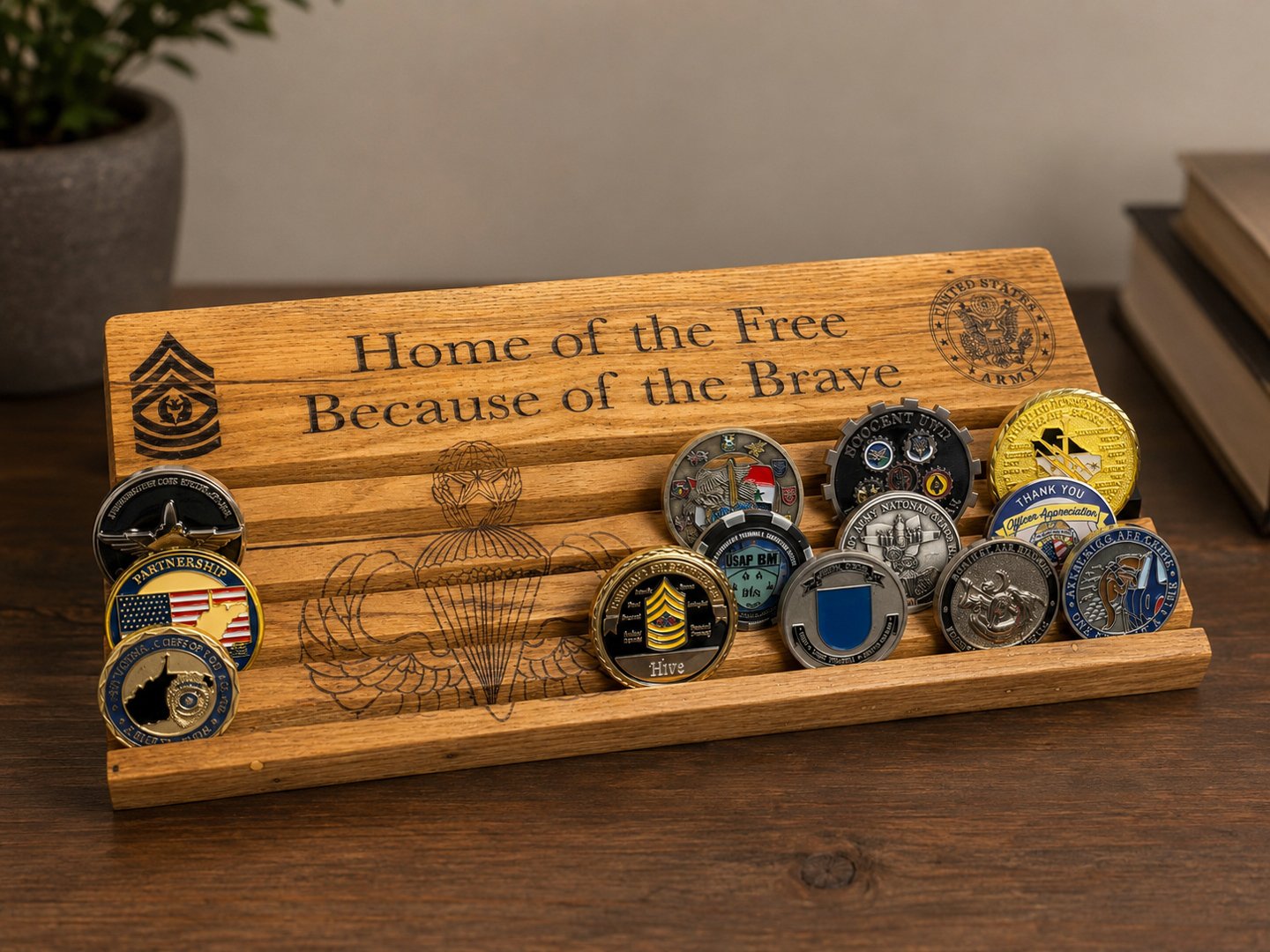 Wooden challenge coin display rack with a backboard reading Home of the Free Because of the Brave and coins in its slots