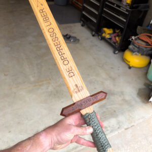 Oak commemorative sword engraved with the words De Oppresso Liber and a paracord-wrapped grip